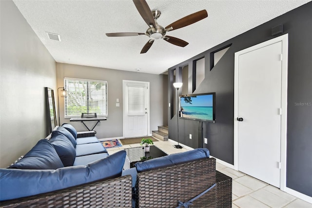 1508 Adams Cir E, Largo, FL 33771 - living room with ceiling fan, a textured ceiling, light tile patterned flooring, and stairs