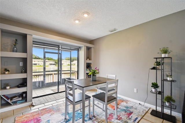 1508 Adams Cir E, Largo, FL 33771 - dining room featuring a textured ceiling, a water view, and light tile patterned floors