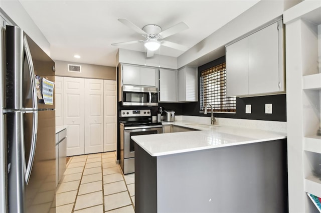 1508 Adams Cir E, Largo, FL 33771 - kitchen featuring appliances with stainless steel finishes, a peninsula, ceiling fan, light countertops, and recessed lighting