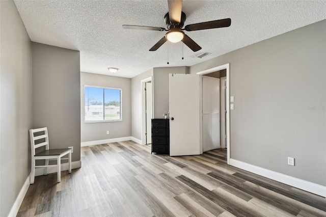 1508 Adams Cir E, Largo, FL 33771 - unfurnished bedroom featuring wood finished floors, a textured ceiling, and ceiling fan