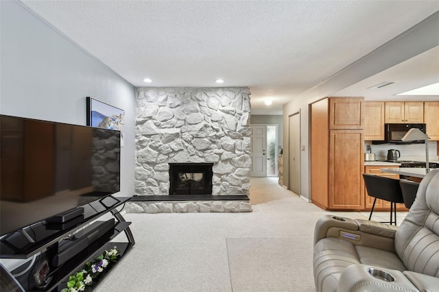 2418 Cardwell Way, Sarasota, FL 34231 - living area with a textured ceiling, light carpet, a stone fireplace, and recessed lighting