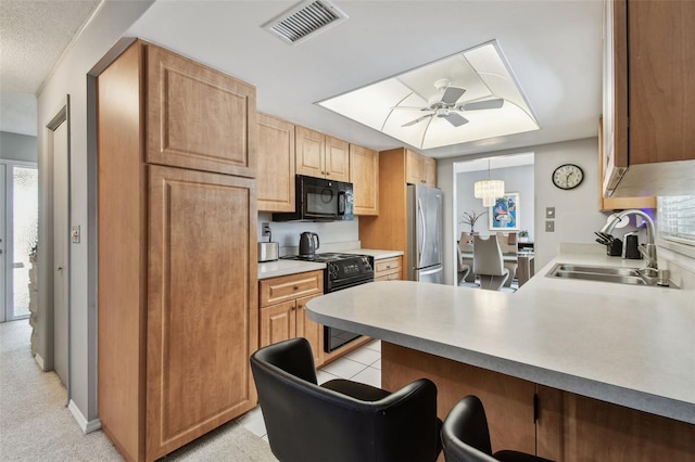 2418 Cardwell Way, Sarasota, FL 34231 - kitchen with black appliances, a ceiling fan, a kitchen bar, a peninsula, and light countertops