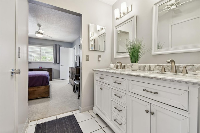 2418 Cardwell Way, Sarasota, FL 34231 - ensuite bathroom featuring a ceiling fan, double vanity, tile patterned floors, and a textured ceiling