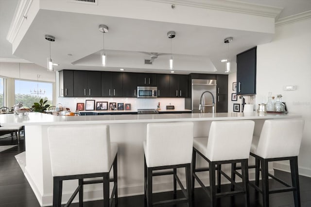2 Seaside Ln Unit 203, Belleair, FL 33756 - kitchen with a raised ceiling, dark cabinetry, stainless steel appliances, light countertops, and tasteful backsplash