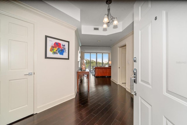 2 Seaside Ln Unit 203, Belleair, FL 33756 - entrance foyer with dark wood-type flooring, ornamental molding, a tray ceiling, and a chandelier