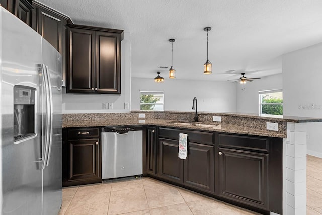 1821 Hawks View Dr, Ruskin, FL 33570 - kitchen featuring appliances with stainless steel finishes, light tile patterned floors, a ceiling fan, dark stone countertops, and pendant lighting