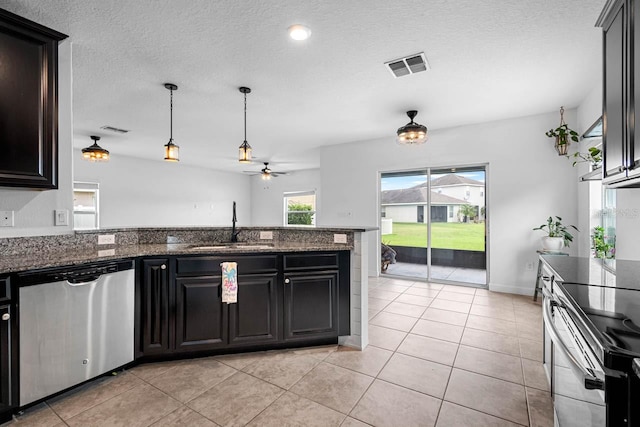 1821 Hawks View Dr, Ruskin, FL 33570 - kitchen with stainless steel appliances, ceiling fan, a peninsula, light tile patterned flooring, and a textured ceiling