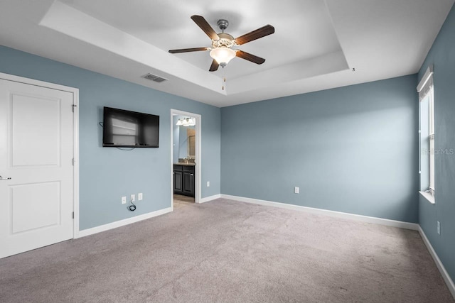 1821 Hawks View Dr, Ruskin, FL 33570 - unfurnished bedroom with a tray ceiling, light carpet, a ceiling fan, and ensuite bathroom