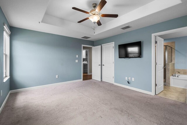 1821 Hawks View Dr, Ruskin, FL 33570 - unfurnished bedroom featuring a raised ceiling, carpet, and ensuite bath