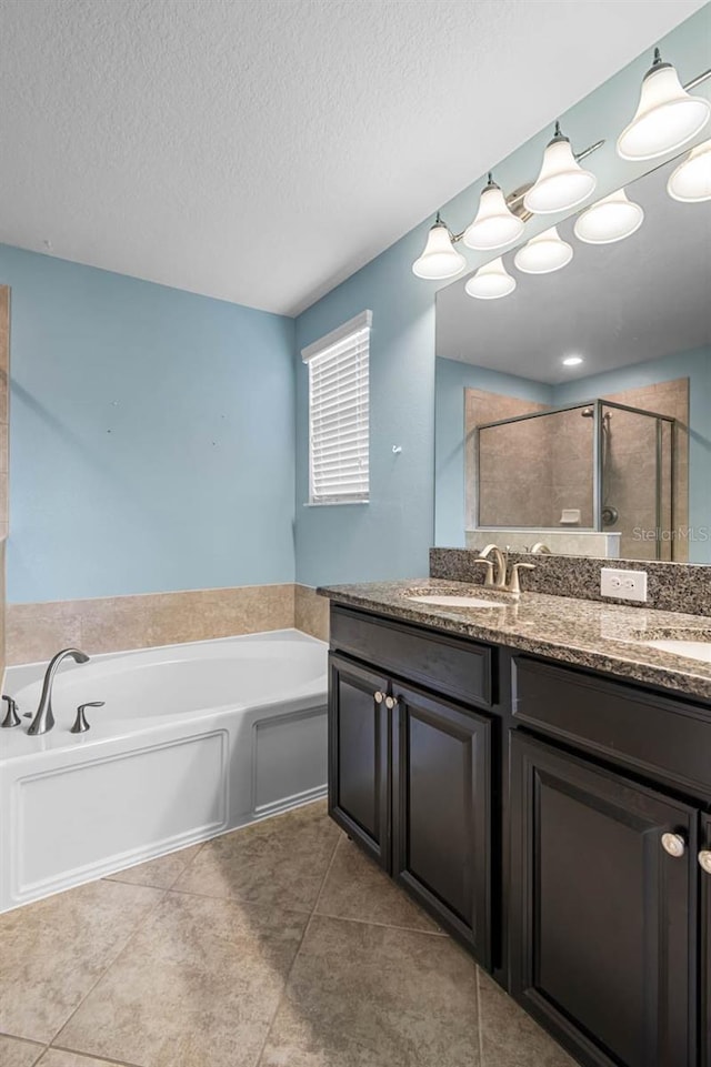 1821 Hawks View Dr, Ruskin, FL 33570 - bathroom with a stall shower, a bath, double vanity, a textured ceiling, and tile patterned floors
