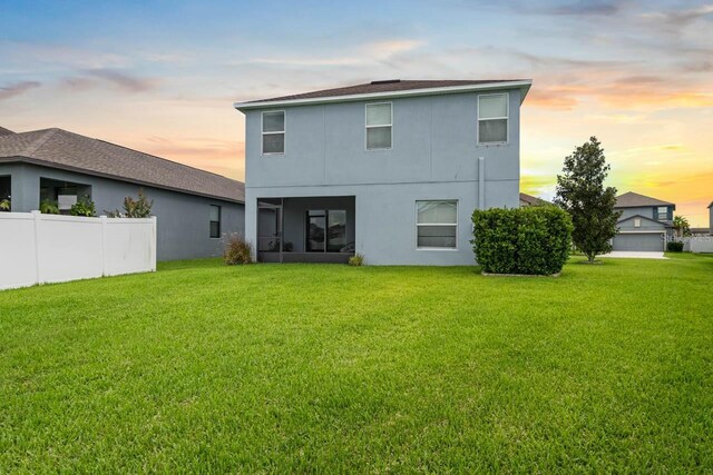 1821 Hawks View Dr, Ruskin, FL 33570 - back of house at dusk featuring stucco siding and a sunroom