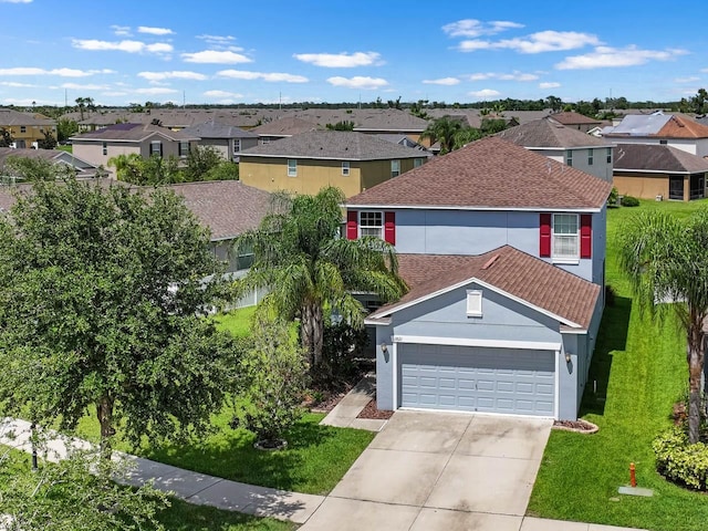 1821 Hawks View Dr, Ruskin, FL 33570 - traditional home with a residential view, a garage, stucco siding, and a front lawn