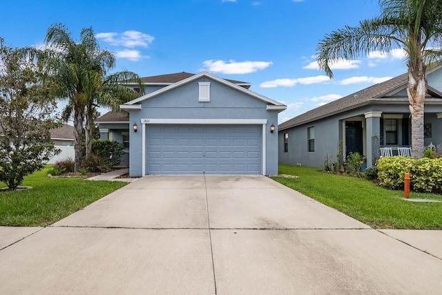 1821 Hawks View Dr, Ruskin, FL 33570 - view of front of house with a front yard, driveway, an attached garage, and stucco siding