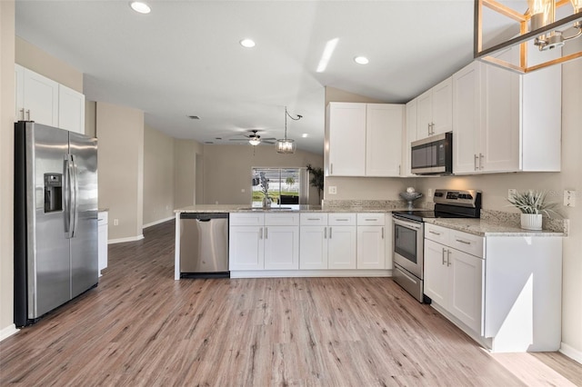 5131 Gato Del Sol Cir, Wesley Chapel, FL 33544 - kitchen with stainless steel appliances, white cabinets, light wood-type flooring, recessed lighting, and a peninsula