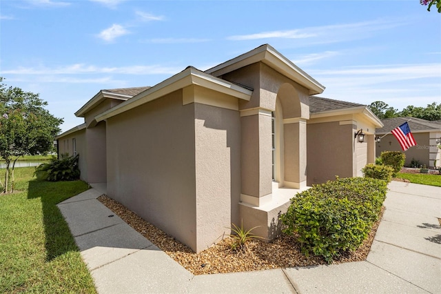 5131 Gato Del Sol Cir, Wesley Chapel, FL 33544 - view of property exterior with an attached garage, stucco siding, a shingled roof, and driveway