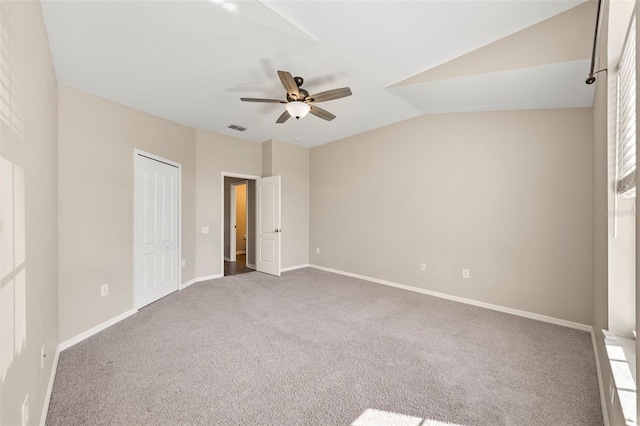 5131 Gato Del Sol Cir, Wesley Chapel, FL 33544 - unfurnished bedroom with carpet flooring, vaulted ceiling, a closet, and a ceiling fan