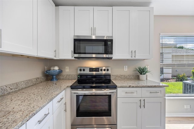 5131 Gato Del Sol Cir, Wesley Chapel, FL 33544 - kitchen with appliances with stainless steel finishes, white cabinets, and healthy amount of natural light