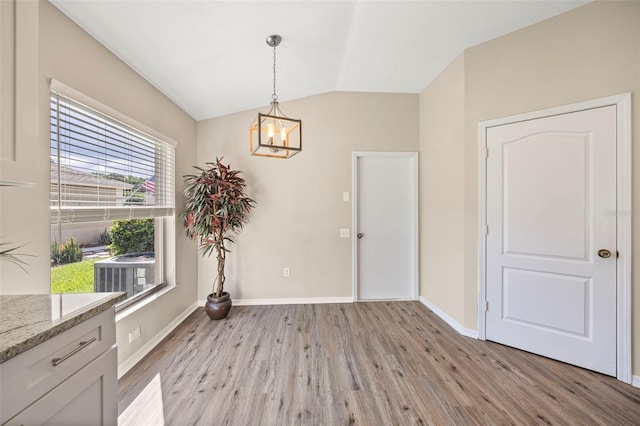 5131 Gato Del Sol Cir, Wesley Chapel, FL 33544 - unfurnished dining area featuring a chandelier, light wood-type flooring, and vaulted ceiling