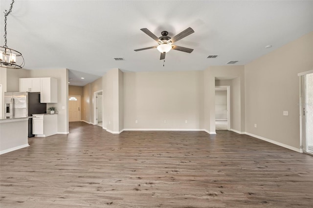 5131 Gato Del Sol Cir, Wesley Chapel, FL 33544 - unfurnished living room with a ceiling fan, wood finished floors, and a chandelier