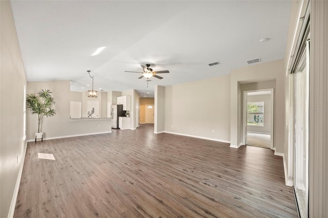 5131 Gato Del Sol Cir, Wesley Chapel, FL 33544 - unfurnished living room featuring a ceiling fan, wood finished floors, and vaulted ceiling