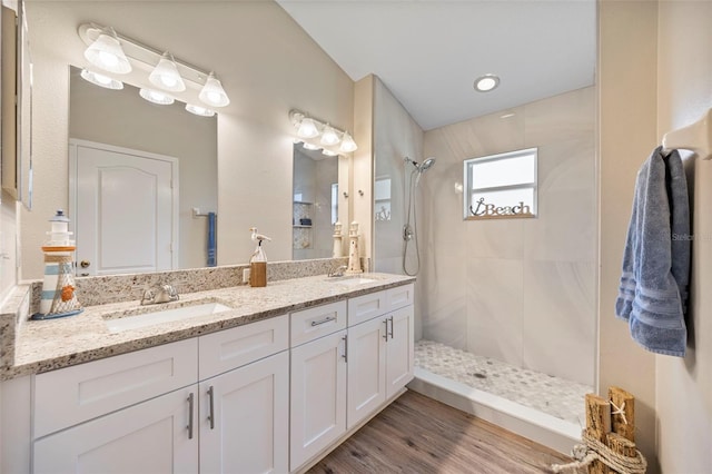 5131 Gato Del Sol Cir, Wesley Chapel, FL 33544 - bathroom featuring tiled shower, double vanity, and wood finished floors