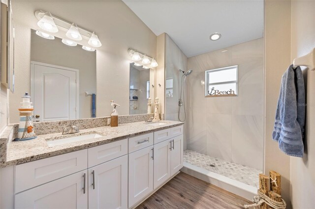 5131 Gato Del Sol Cir, Wesley Chapel, FL 33544 - bathroom featuring tiled shower, double vanity, and wood finished floors