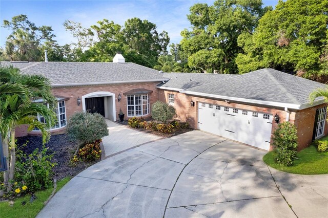 302 Eastleigh Dr, Belleair, FL 33756 - ranch-style home with brick siding, driveway, an attached garage, and a chimney