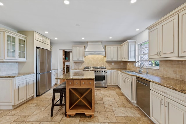 302 Eastleigh Dr, Belleair, FL 33756 - kitchen with appliances with stainless steel finishes, custom range hood, stone tile flooring, cream cabinets, and recessed lighting