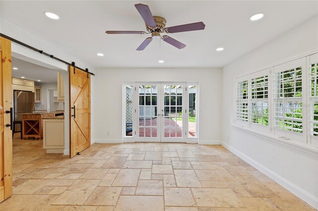 302 Eastleigh Dr, Belleair, FL 33756 - empty room with a barn door, stone tile flooring, recessed lighting, a ceiling fan, and french doors
