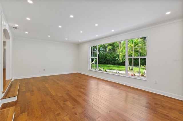 302 Eastleigh Dr, Belleair, FL 33756 - empty room featuring crown molding, arched walkways, wood finished floors, and recessed lighting