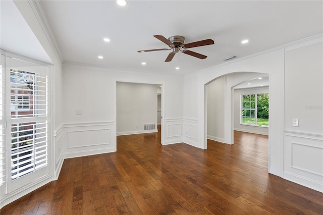 302 Eastleigh Dr, Belleair, FL 33756 - empty room with arched walkways, a decorative wall, ceiling fan, wood-type flooring, and wainscoting