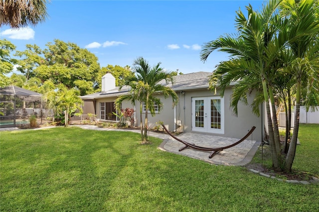 302 Eastleigh Dr, Belleair, FL 33756 - rear view of house featuring french doors, stucco siding, a patio, and a chimney