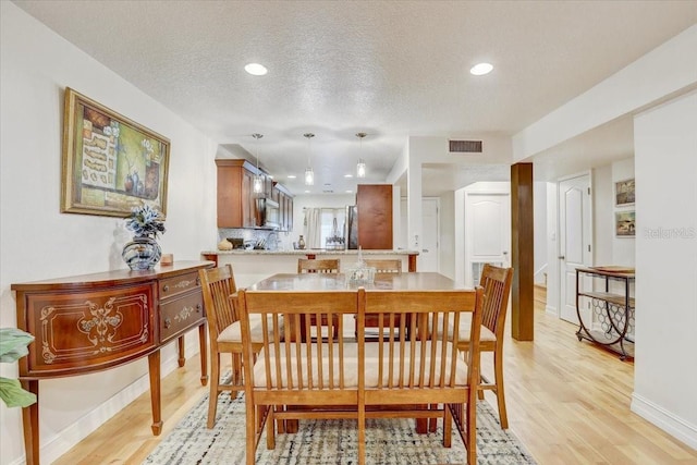 2078 Sunset Point Rd Unit 83, Clearwater, FL 33765 - dining space with light wood-style flooring, recessed lighting, and a textured ceiling