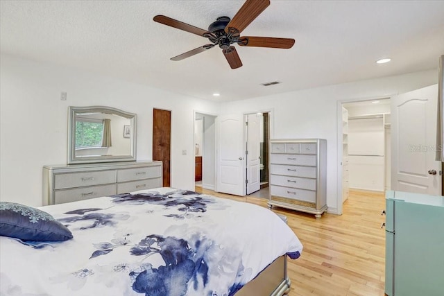 2078 Sunset Point Rd Unit 83, Clearwater, FL 33765 - bedroom featuring a spacious closet, light wood finished floors, recessed lighting, a ceiling fan, and a closet
