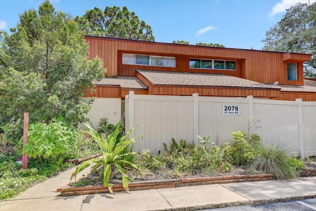 2078 Sunset Point Rd Unit 83, Clearwater, FL 33765 - view of front facade with a fenced front yard and roof with shingles