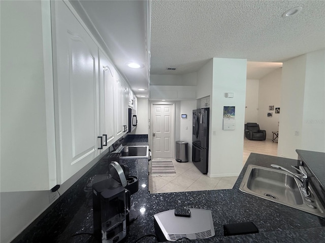 199 N Crystal Meadow Path, Lecanto, FL 34461 - kitchen featuring black fridge with ice dispenser, stainless steel microwave, white cabinets, a textured ceiling, and dark countertops