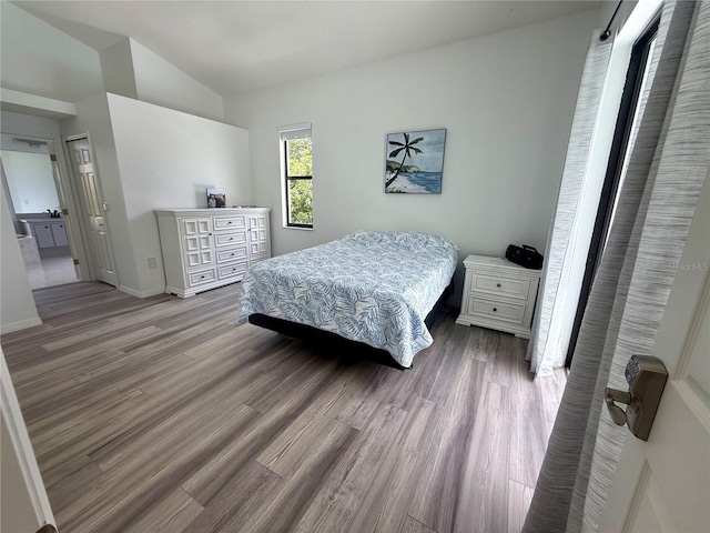 199 N Crystal Meadow Path, Lecanto, FL 34461 - bedroom with wood finished floors, vaulted ceiling, and ensuite bathroom