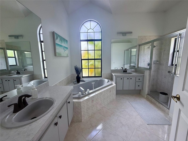 199 N Crystal Meadow Path, Lecanto, FL 34461 - bathroom featuring plenty of natural light, a shower stall, two vanities, a bath, and vaulted ceiling