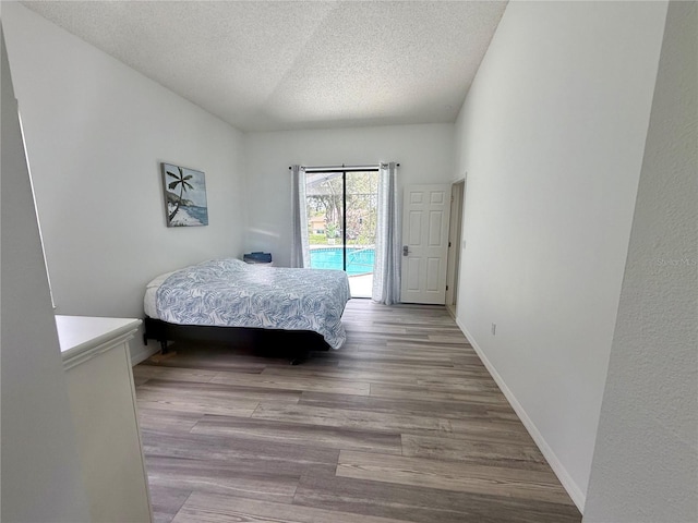 199 N Crystal Meadow Path, Lecanto, FL 34461 - bedroom with access to exterior, a textured ceiling, and wood finished floors