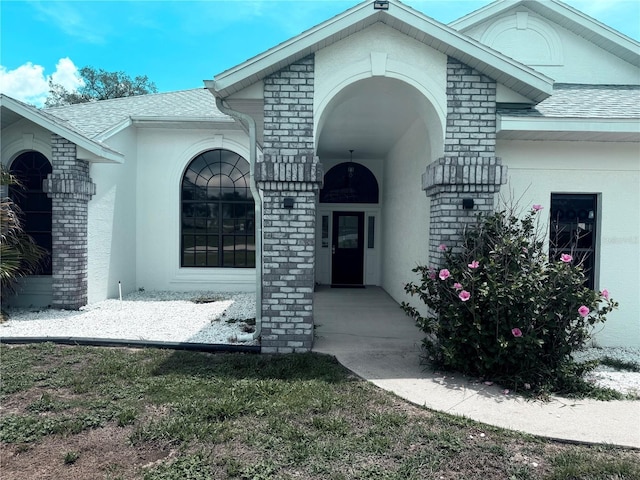 199 N Crystal Meadow Path, Lecanto, FL 34461 - property entrance with brick siding, roof with shingles, and stucco siding