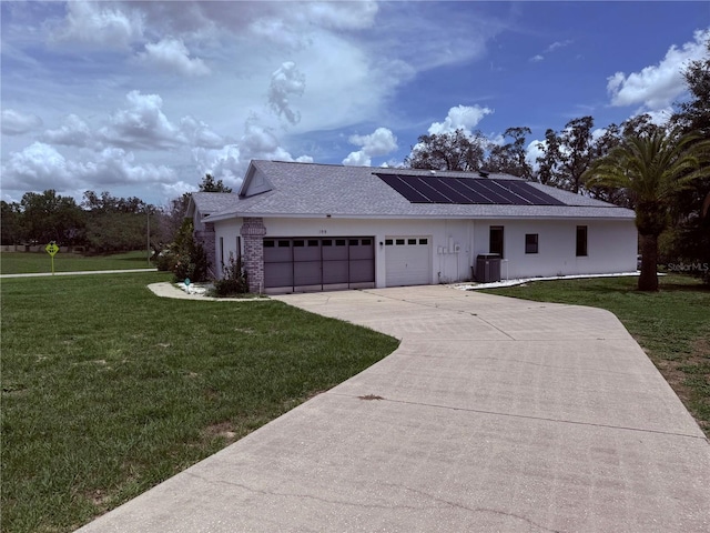 199 N Crystal Meadow Path, Lecanto, FL 34461 - view of front of house featuring a front yard, an attached garage, solar panels, driveway, and a shingled roof