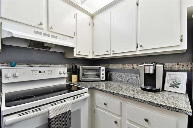 255 Dolphin Pt Unit 207, Clearwater Beach, FL 33767 - kitchen featuring electric stove, under cabinet range hood, white cabinetry, and tasteful backsplash