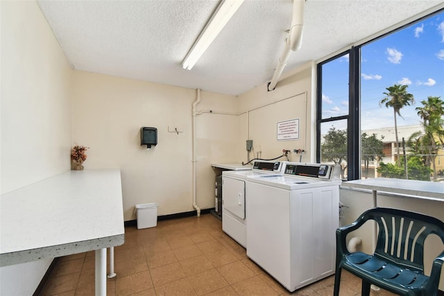 255 Dolphin Pt Unit 207, Clearwater Beach, FL 33767 - communal laundry room with washing machine and dryer, a textured ceiling, and light flooring