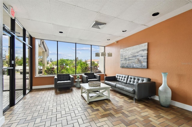 255 Dolphin Pt Unit 207, Clearwater Beach, FL 33767 - living area featuring expansive windows and a drop ceiling