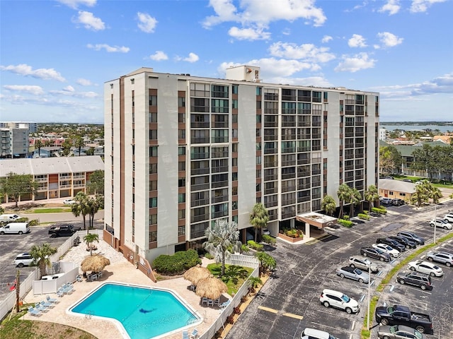 255 Dolphin Pt Unit 207, Clearwater Beach, FL 33767 - view of building exterior with uncovered parking and a community pool