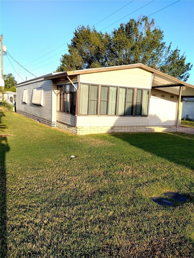 6443 Midland St, Zephyrhills, FL 33542 - back of house featuring a yard and a sunroom