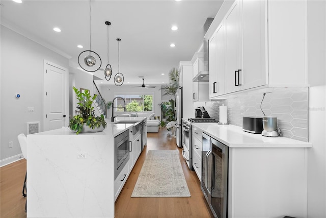 4515 W N A St Unit 6, Tampa, FL 33609 - kitchen featuring appliances with stainless steel finishes, beverage cooler, white cabinets, light wood-style flooring, and a ceiling fan