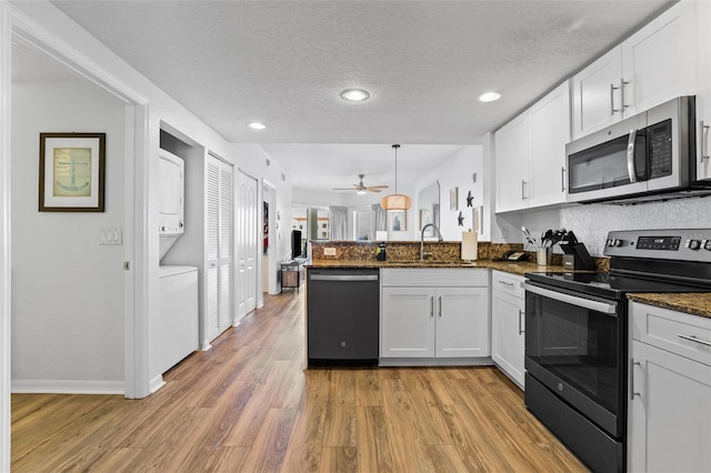 12000 Gulf Blvd Unit 506N, Treasure Island, FL 33706 - kitchen with stainless steel appliances, a peninsula, ceiling fan, white cabinets, and light wood-style flooring
