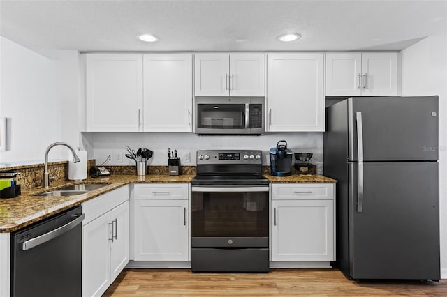 12000 Gulf Blvd Unit 506N, Treasure Island, FL 33706 - kitchen with stainless steel appliances, white cabinets, dark stone counters, and recessed lighting