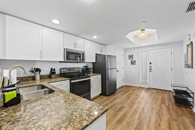 12000 Gulf Blvd Unit 506N, Treasure Island, FL 33706 - kitchen with appliances with stainless steel finishes, white cabinetry, light wood-type flooring, stone countertops, and recessed lighting